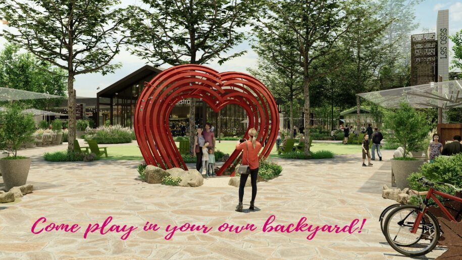 Come play in your own backyard, heart sculpture with people underneath having their picture taken